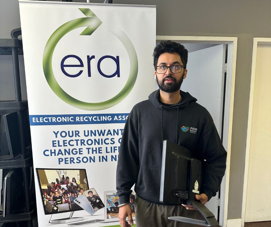 A community organisation representative receiving refurbished technology through ERA