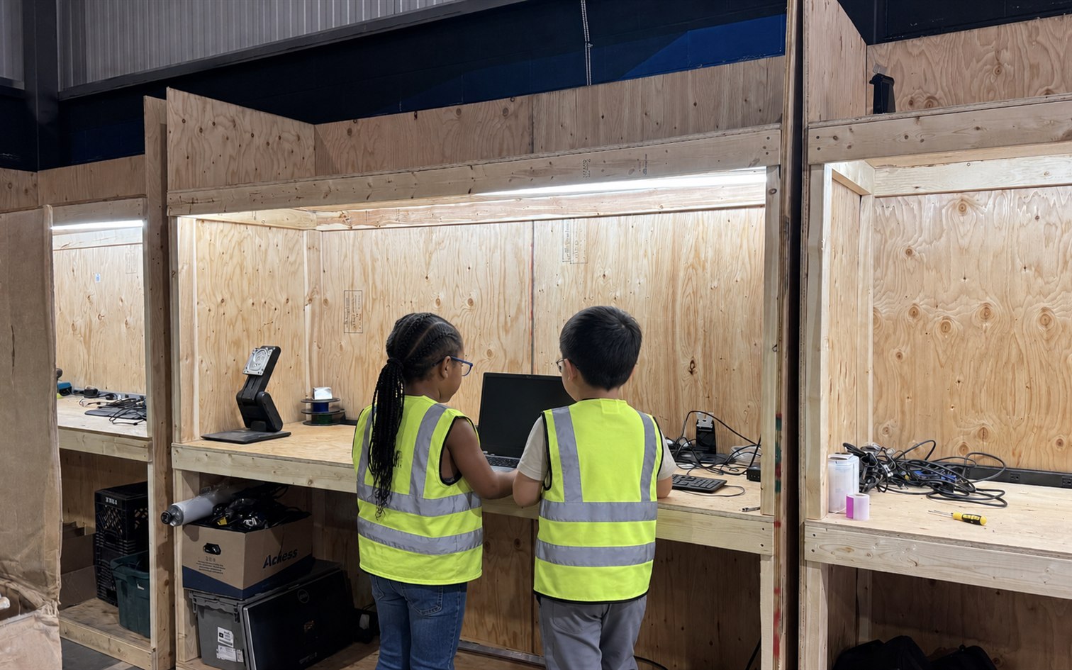 Young people learning computer skills together at an ERA workshop bench