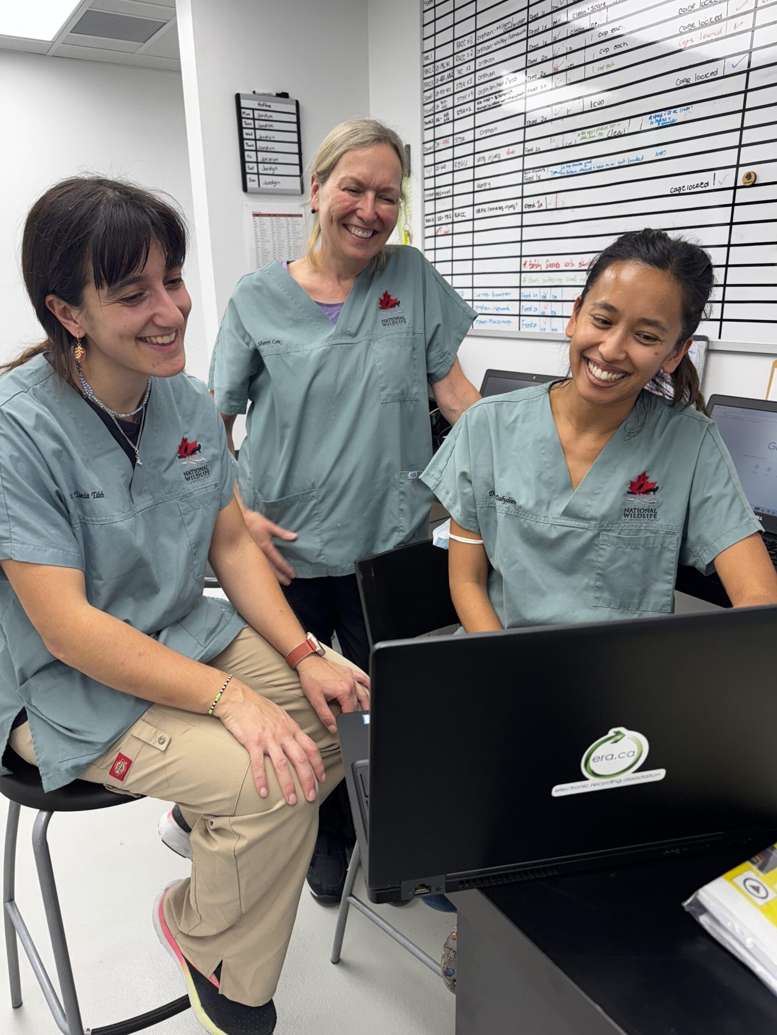 Charity staff using a donated ERA laptop together
