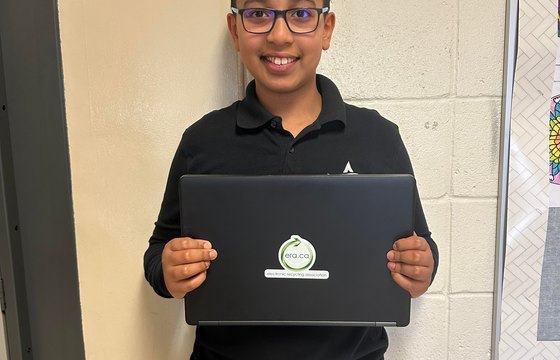 A student holding a refurbished ERA laptop